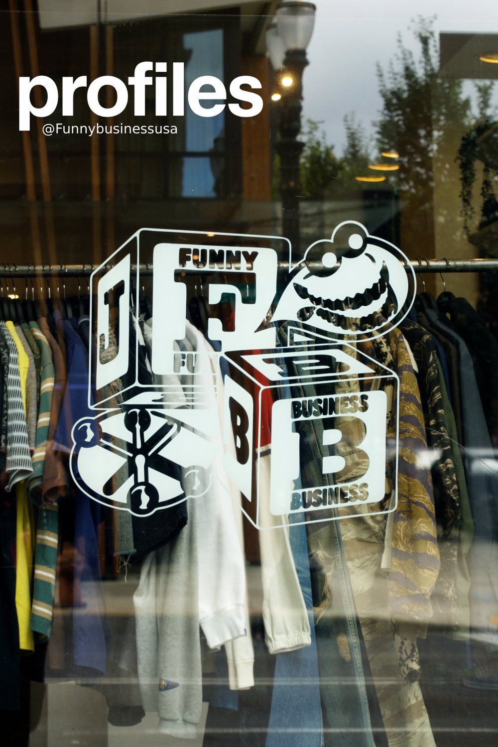 Funny Business window decal over a rack of clothes at the Machus pop-up